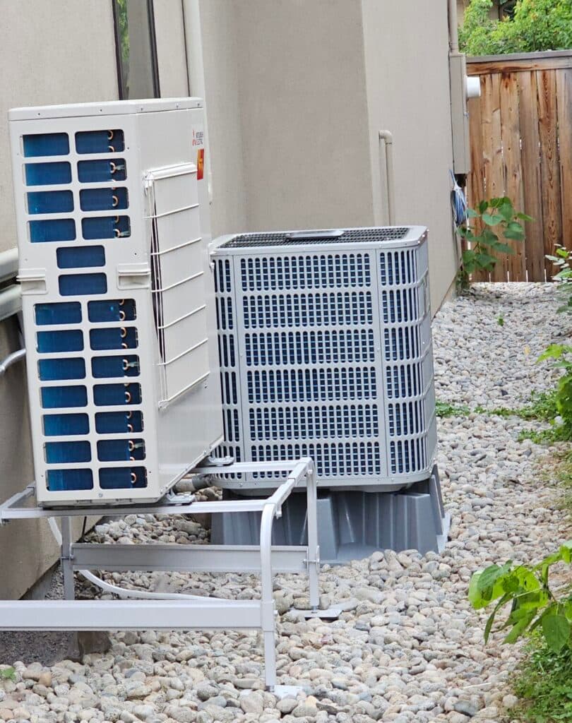 A heat pump and condenser installed on stands beside a Denver home