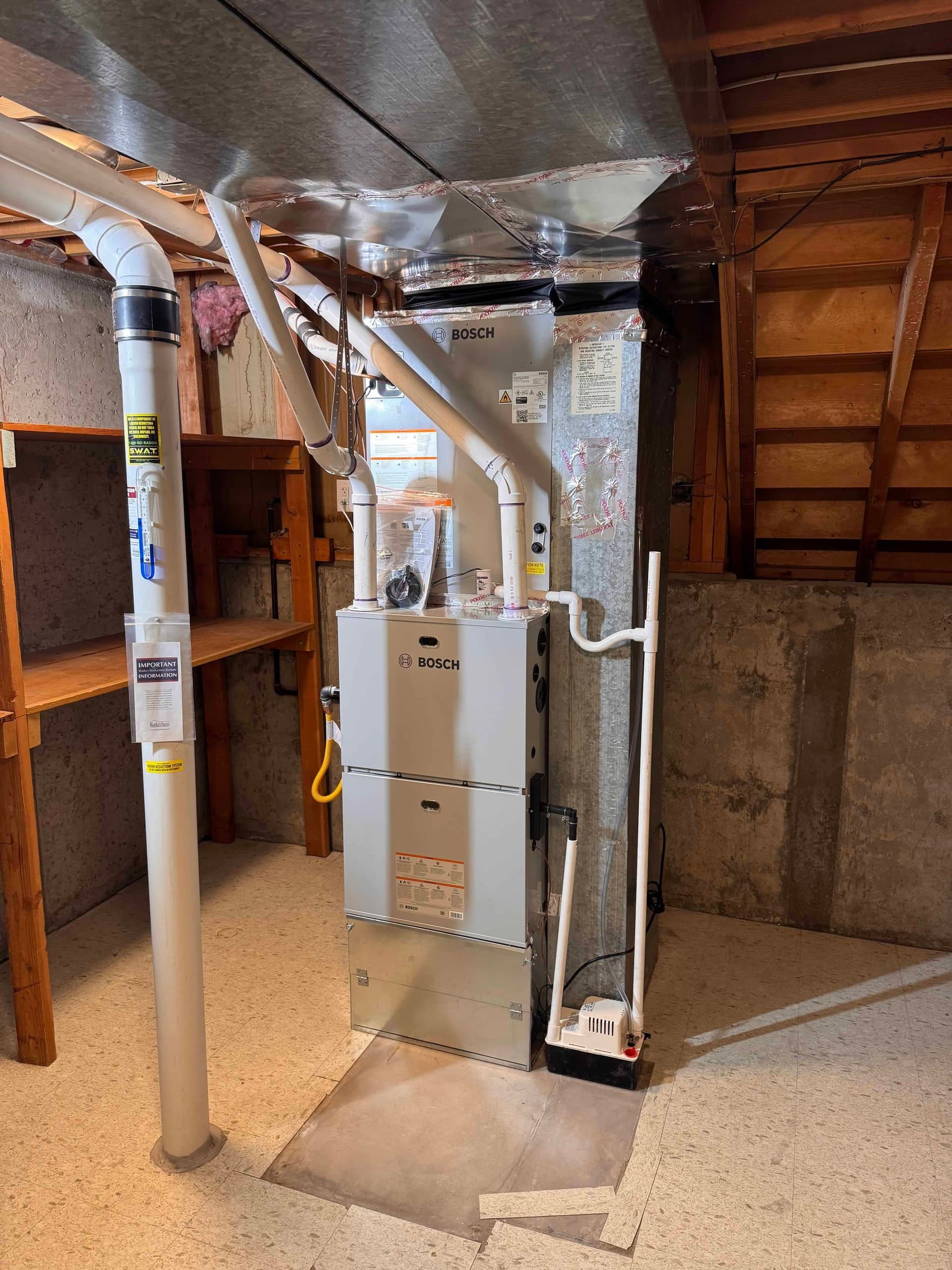 Bosch furnace in basement with concrete walls and yellow label