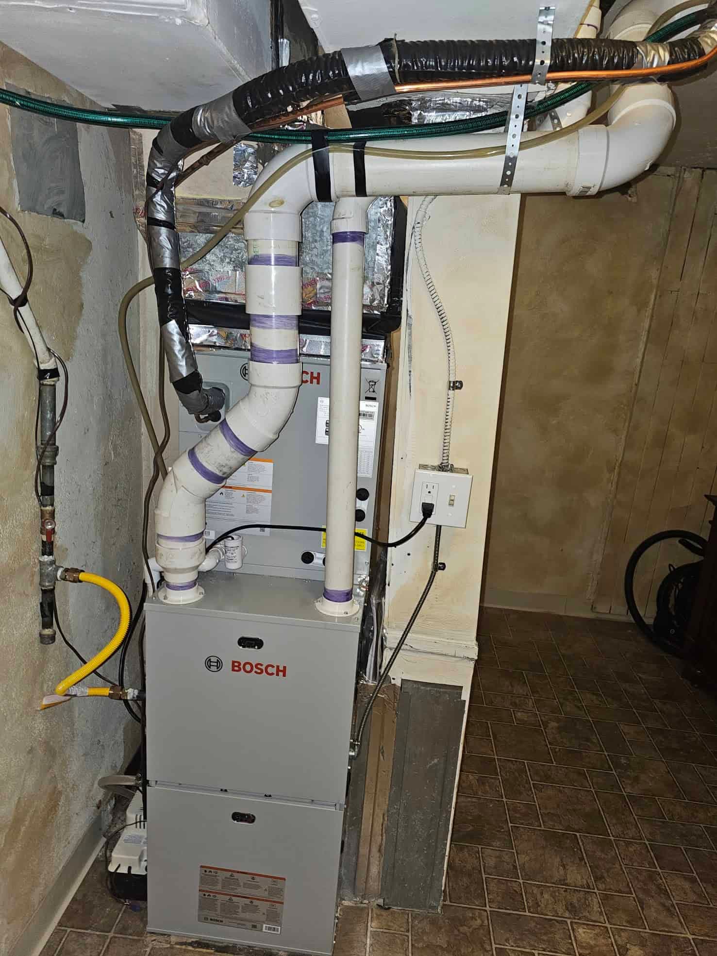 Bosch furnace in basement with purple tape on pipes