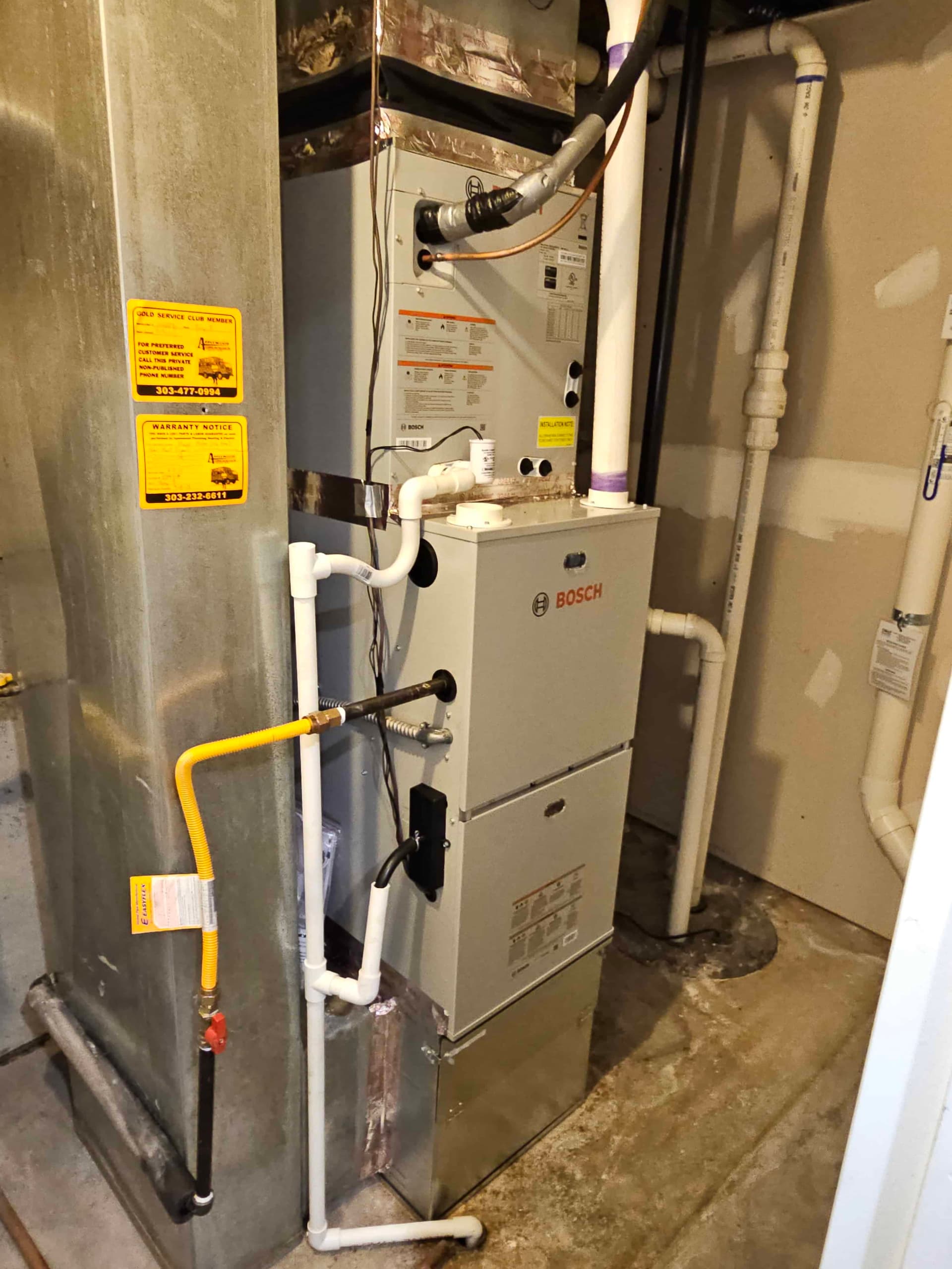 Bosch furnace in mechanical room with yellow service tag