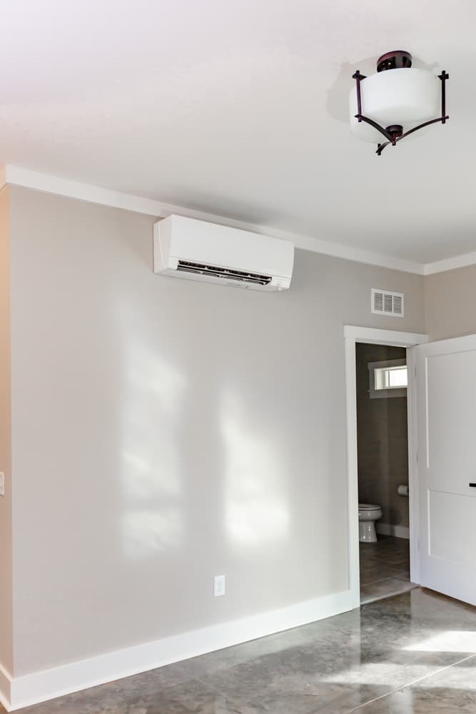 Mitsubishi wall-mounted mini split head installed high on a bedroom wall