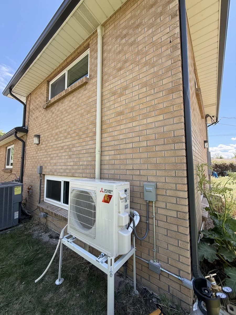 Mini-split outdoor unit on a wall stand at a Wheat Ridge brick home