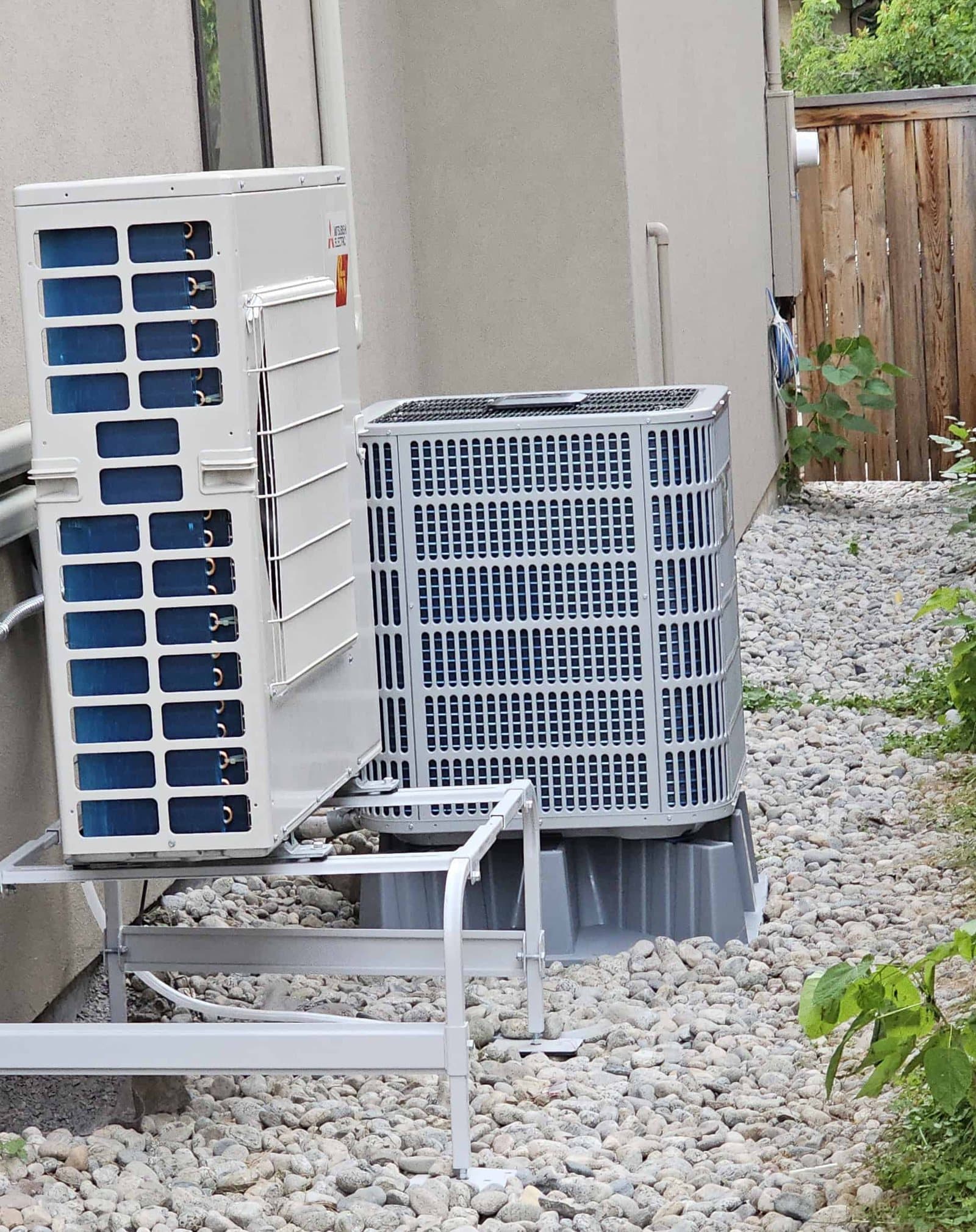 Two different outdoor heat pump units installed side by side at a Denver home
