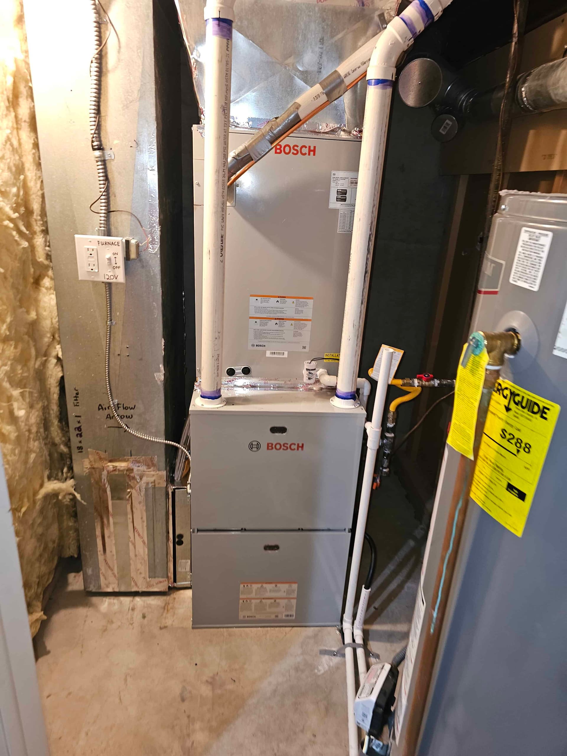 Bosch furnace and air handler in basement with insulation and yellow service tag