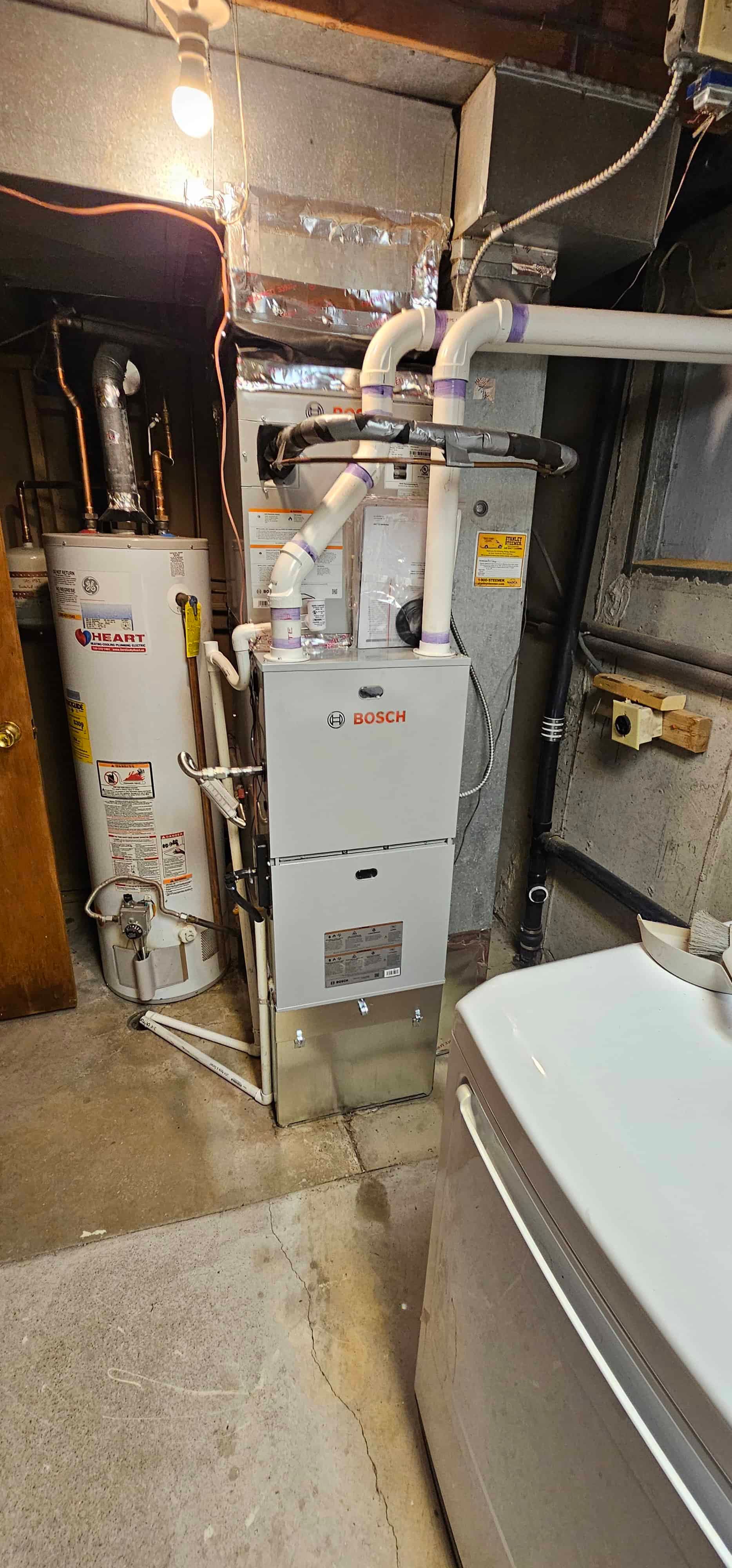 Bosch furnace and water heater in laundry room with concrete floor