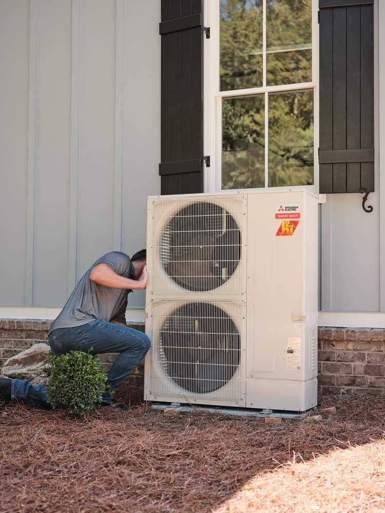 UniColorado technician installing a Mitsubishi mini-split outdoor unit in Denver
