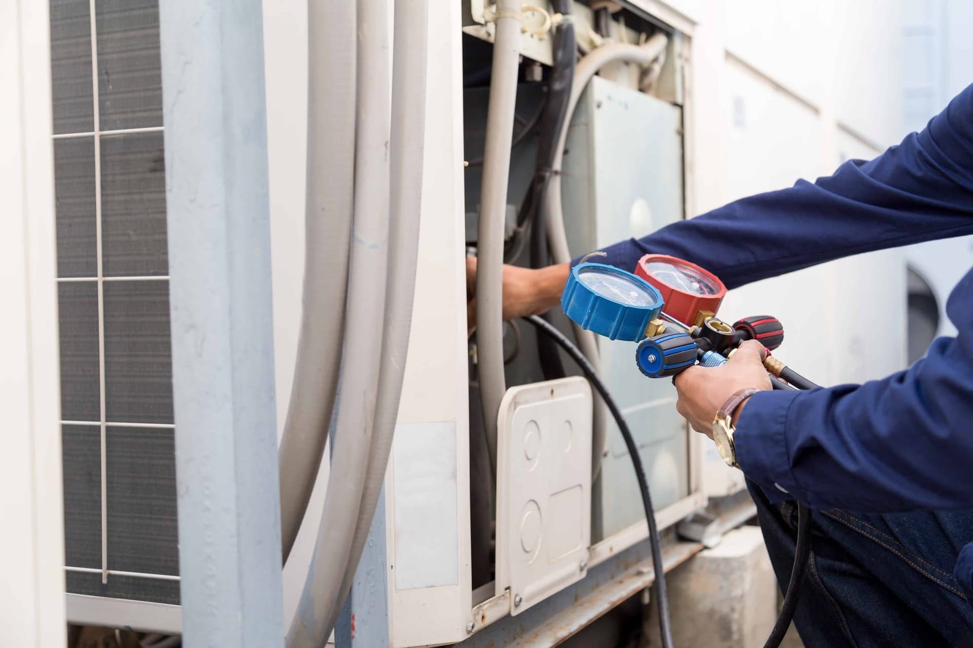 UniColorado technician checking refrigerant gauges on an outdoor AC unit