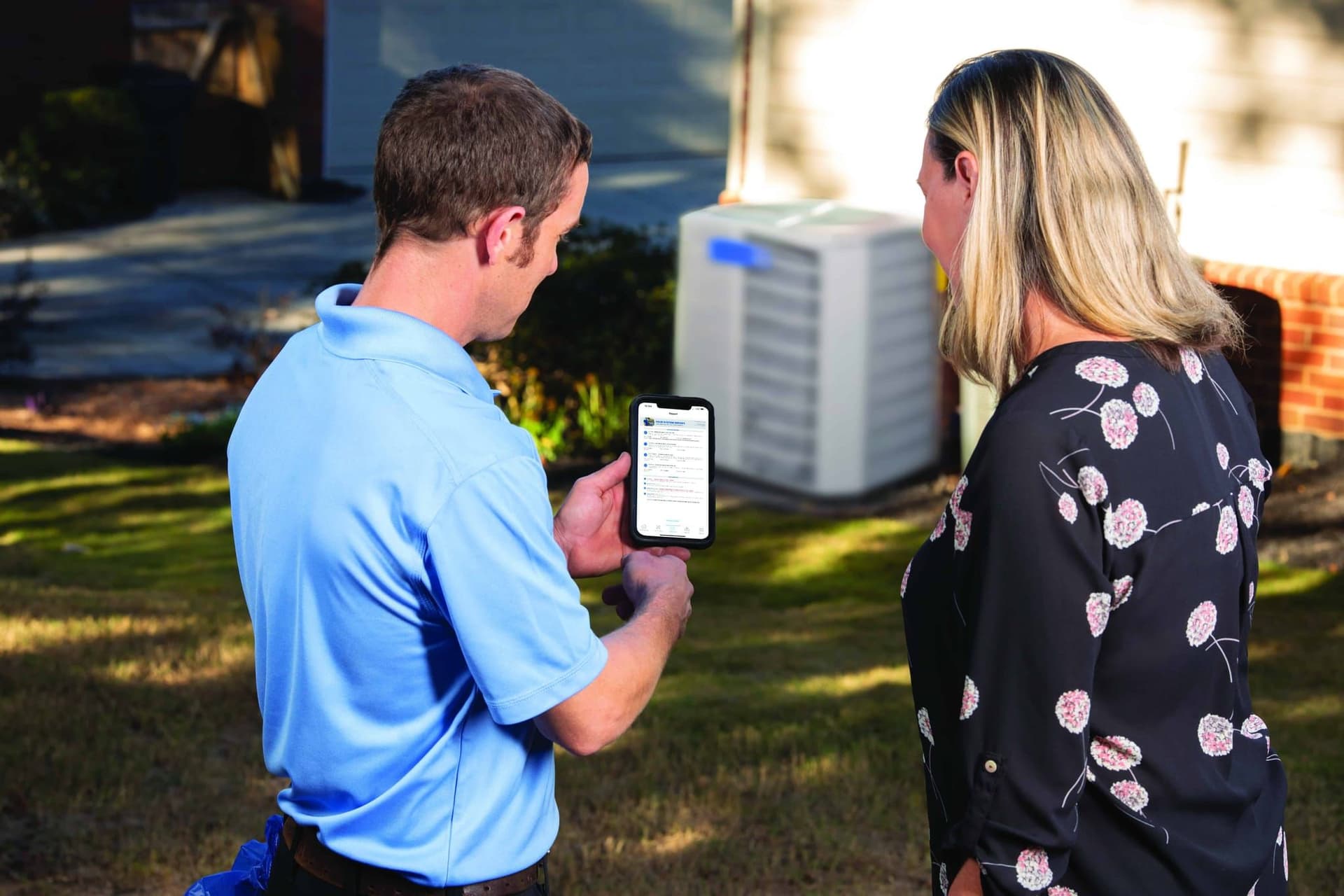 UniColorado technician showing a homeowner the app outside their home